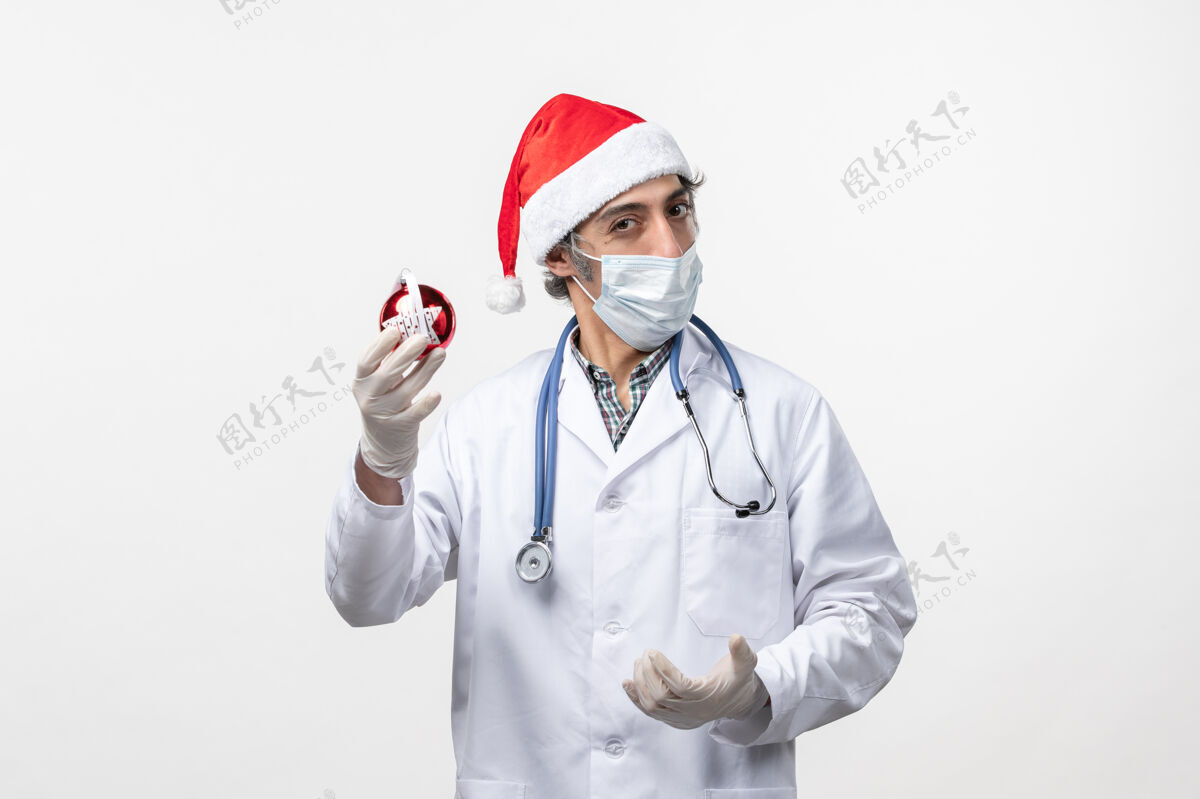 外套正面图戴着面具的男医生带着玩具上了白墙健康假日冠状病毒视图男医生药品