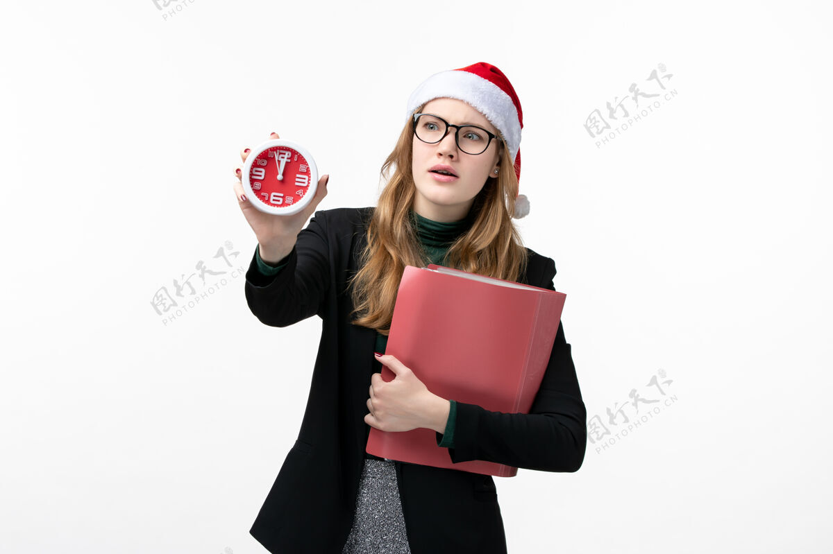 文件正面图年轻女性拿着文件和时钟在白色墙纸上新年圣诞肖像漂亮年轻的女性