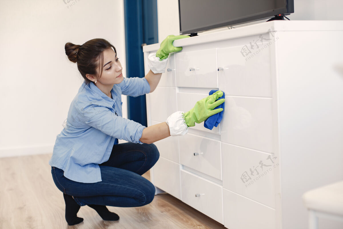 女性带着海绵和橡胶手套的女人在打扫房子清洁工作手套