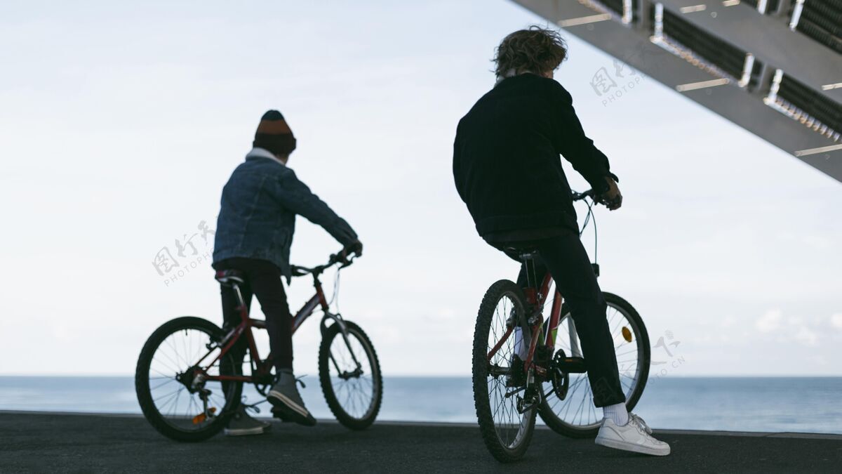 户外城市里男孩骑着自行车在户外的背影活跃乐趣放松