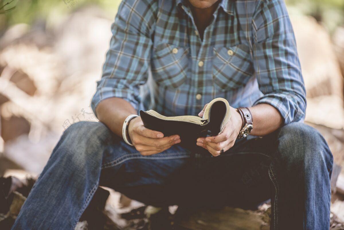 开放特写镜头一个男人穿着休闲服在模糊的背景上阅读圣经阅读祈祷福音