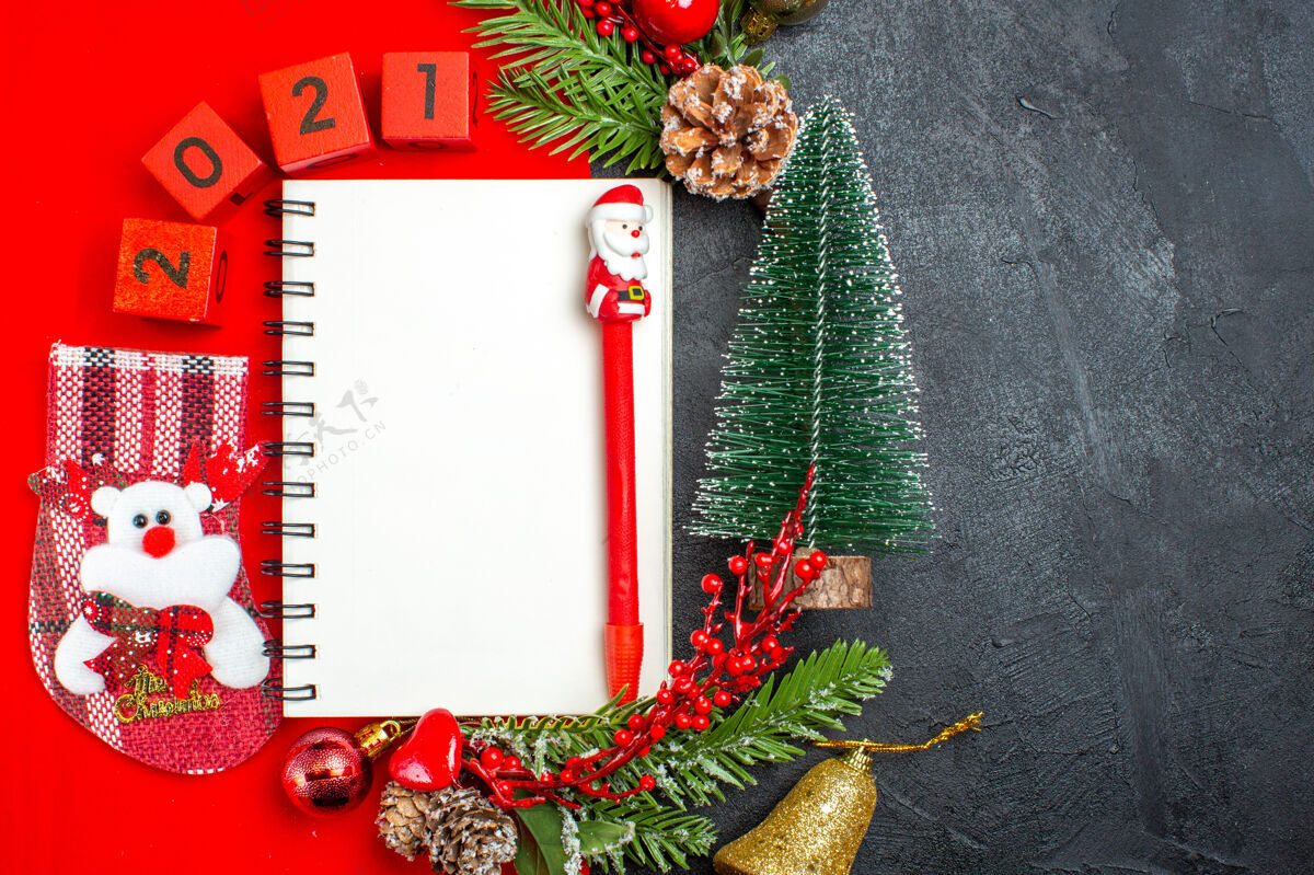 数字上图为黑色背景上的螺旋笔记本装饰配件杉木树枝xsmas袜子编号红色餐巾和圣诞树视图螺旋笔记本树枝