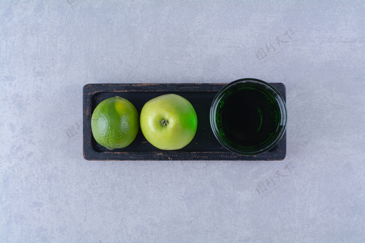 木材柠檬 苹果和苹果汁放在木盘上 放在大理石桌上苹果美味有机