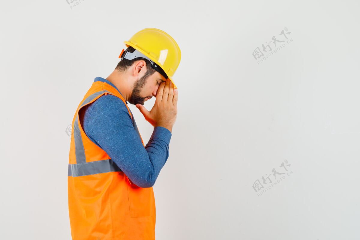 安全帽穿着衬衫的年轻建筑工人手牵手祈祷工厂设备职业