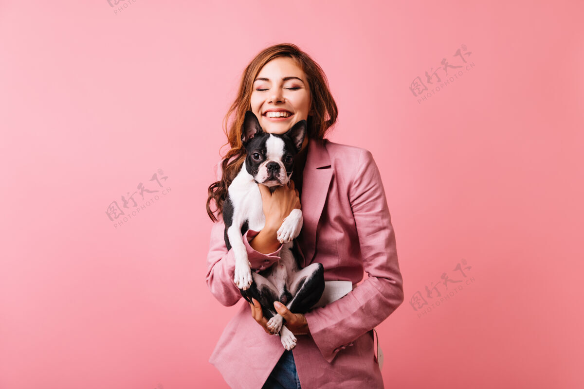 快乐快乐美丽的女孩抱着法国斗牛犬 微笑着闭上眼睛浪漫的红发女人的肖像与小狗隔离在粉红色最好的朋友友谊快乐