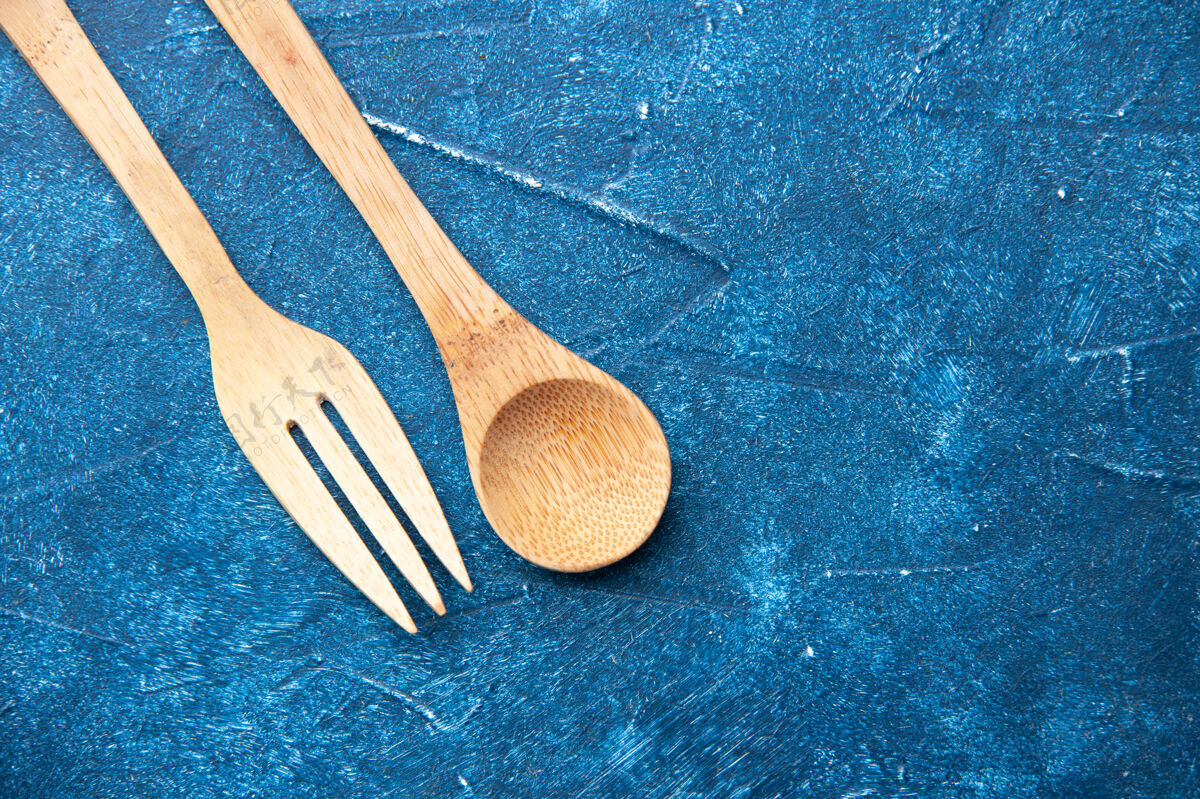 木头勺子顶视图木制叉子勺子放在蓝色桌子上自由活动烹饪地方饭