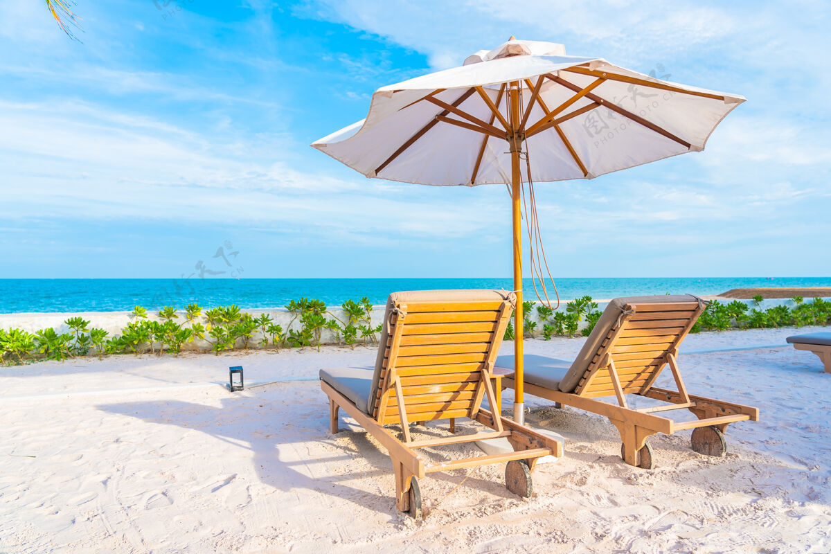 度假村酒店度假区的户外游泳池周围有雨伞和躺椅 有海边沙滩和椰子树放松海岸海滩