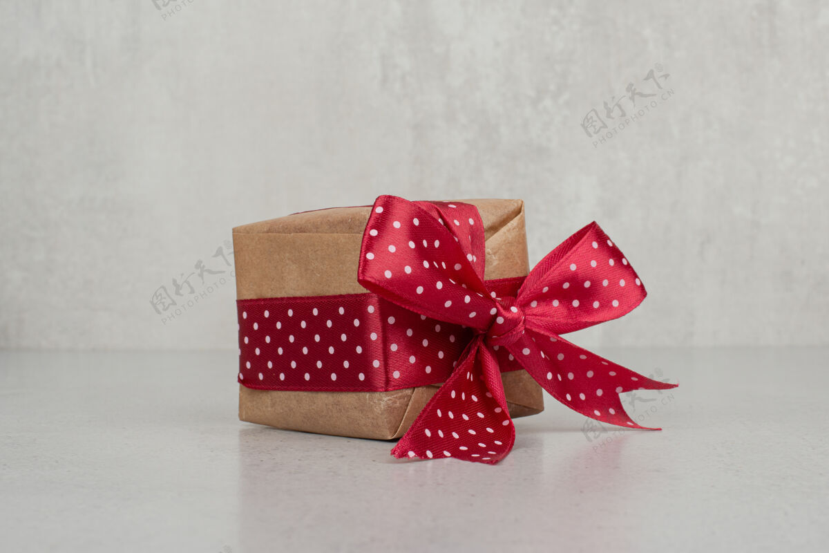 蝴蝶结白墙上有一个红色蝴蝶结的小礼盒装饰庆典节日