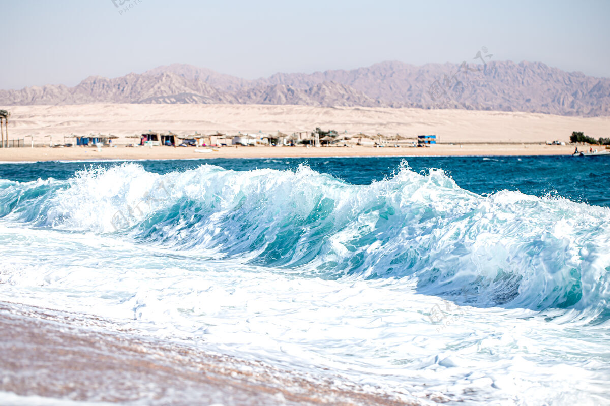 地中海在阳光明媚的天气里 汹涌的大海和泡沫般的海浪可以看到群山环绕的海岸风暴地平线海滩