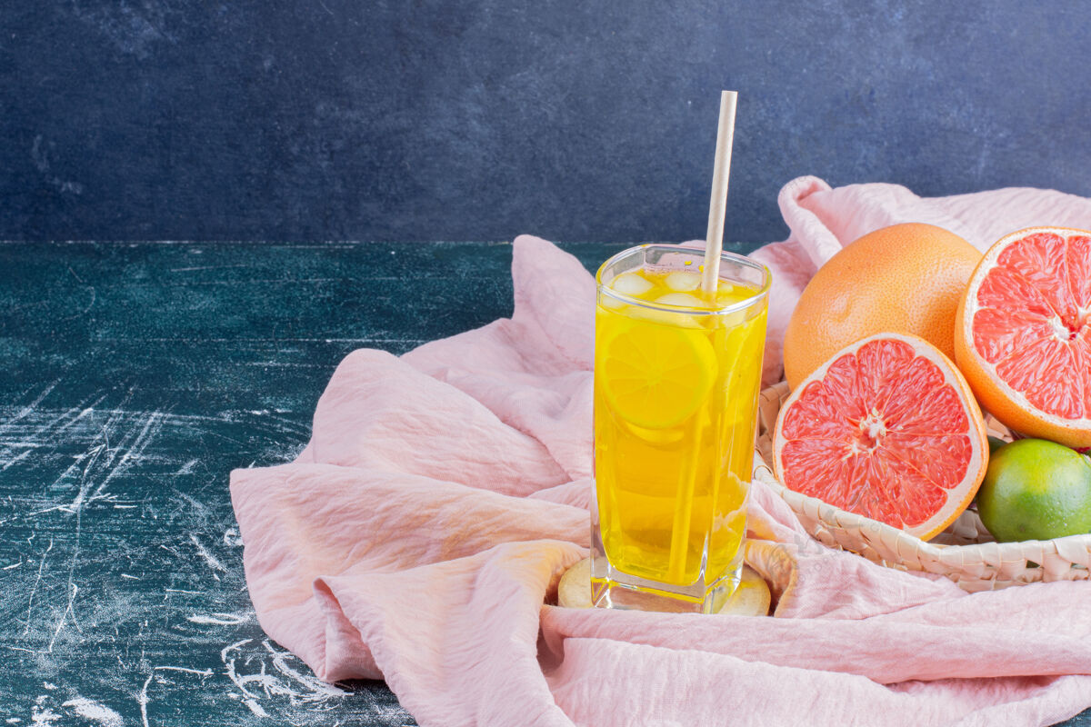桌布一杯柠檬水 柠檬片和葡萄柚放在大理石表面果汁葡萄柚切片