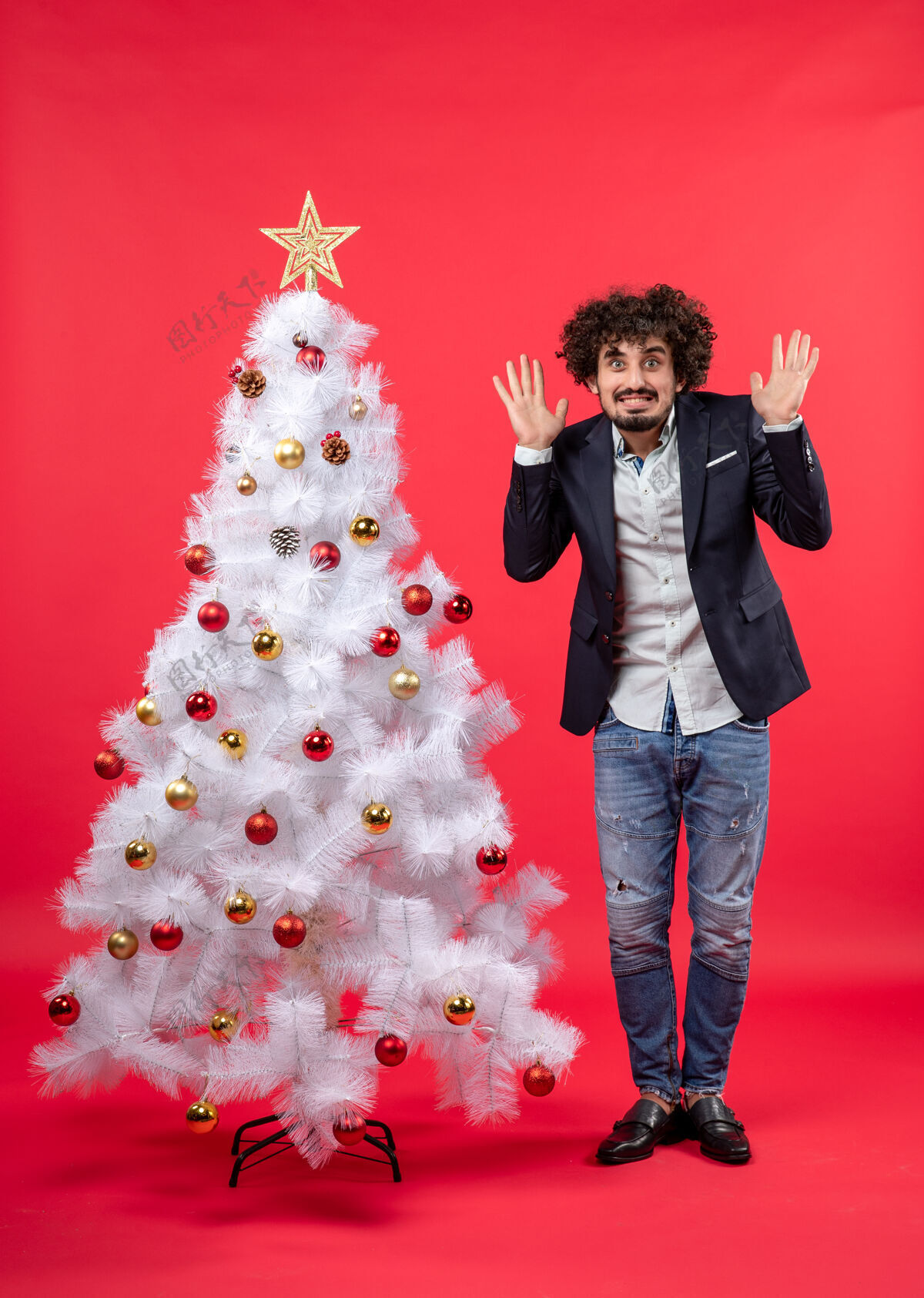 圣诞节圣诞庆典上 留着胡子的年轻人站在圣诞树旁 感到非常害怕圣诞树感觉害怕