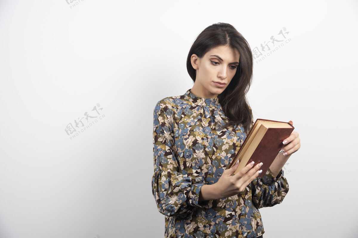 黑发美女在读一本书的名字姿势情感美丽