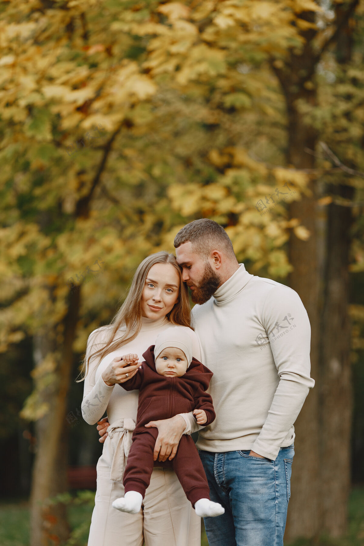 年轻秋天公园里的一家人穿棕色毛衣的男人和父母在一起的可爱小女孩户外男性快乐