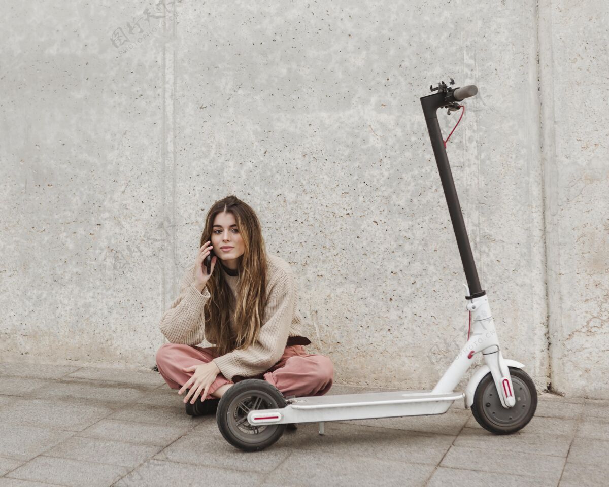 城市交通一个年轻的女人和一辆电动滑板车摆姿势骑手Escooter电动滑板车