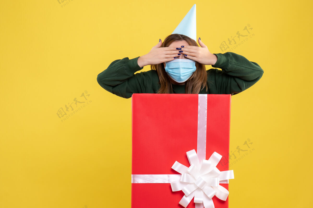 盒子礼物盒里戴面具的年轻女性的正面图内部礼物女性