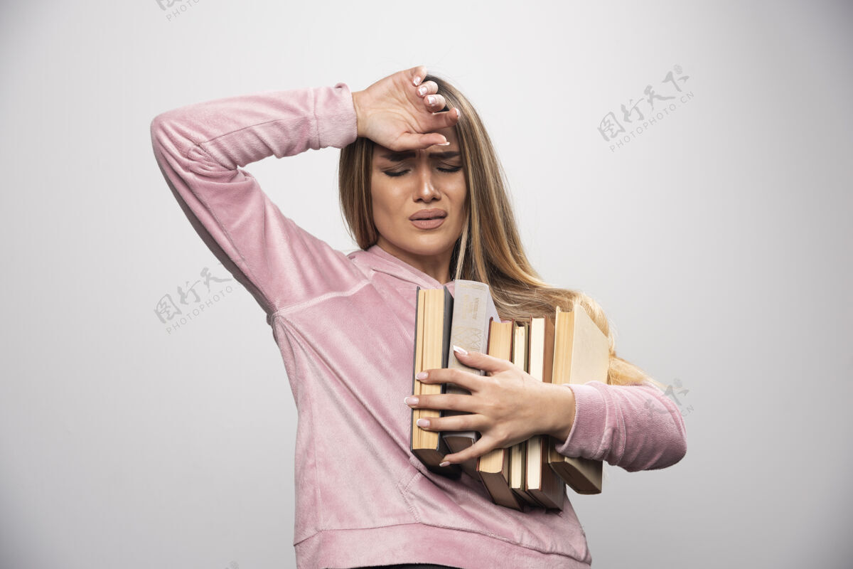 姿势穿着粉色衬衫的女孩手里拿着一堆书 觉得很累携带学习员工
