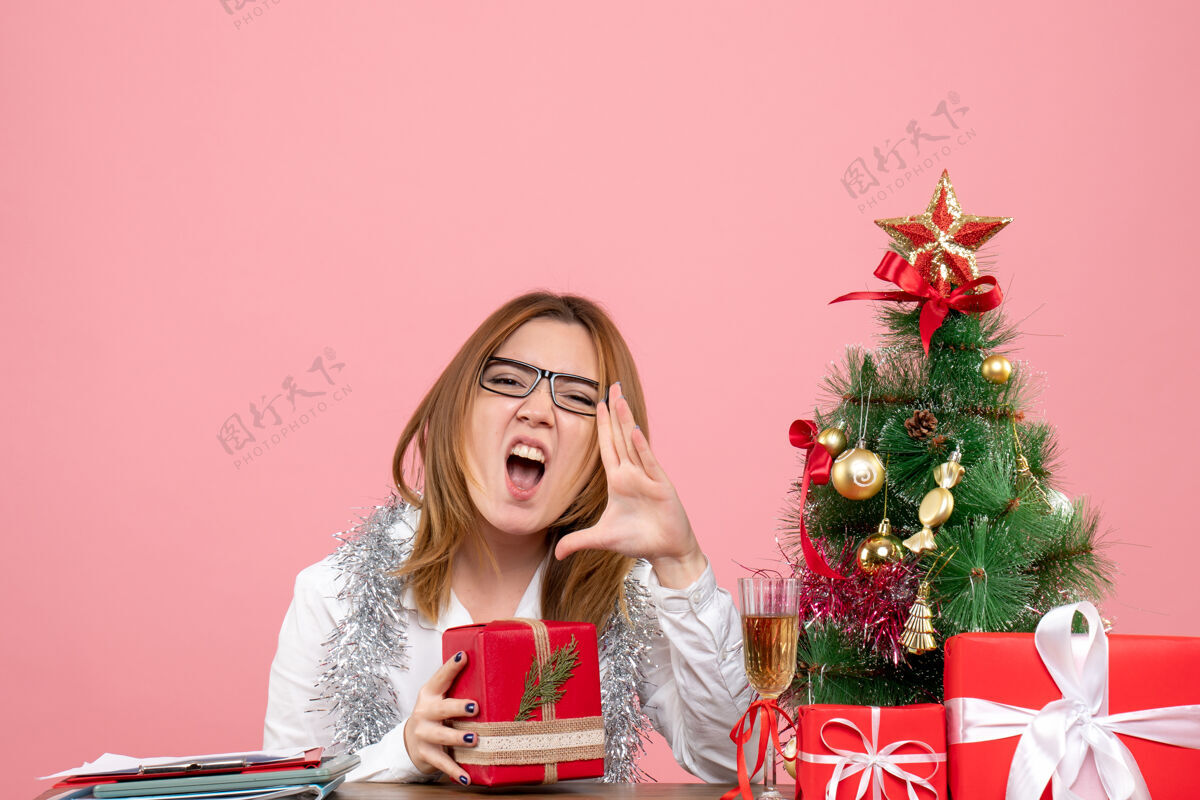 肖像女工正坐在粉红色的椅子上 手里拿着圣诞礼物女工工作工作