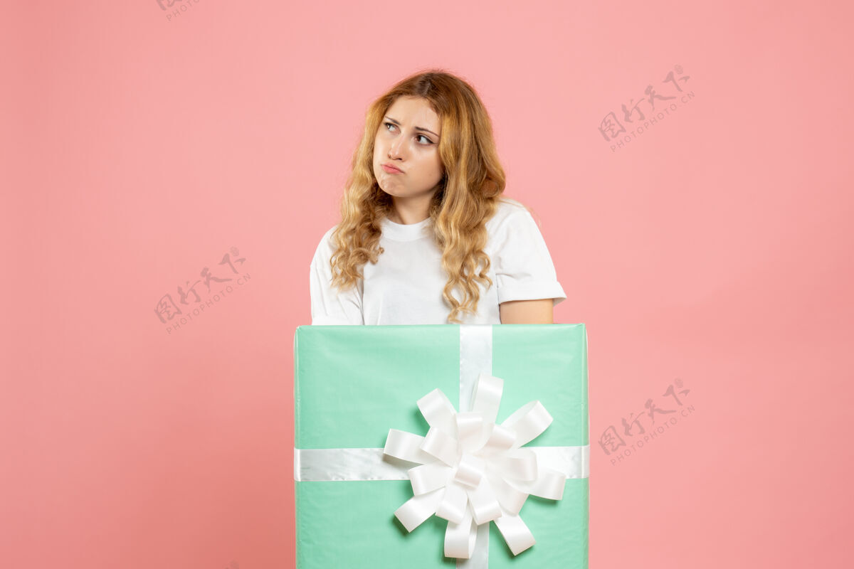 蓝色正面图：站在蓝色礼品盒内的年轻女性节日情感里面