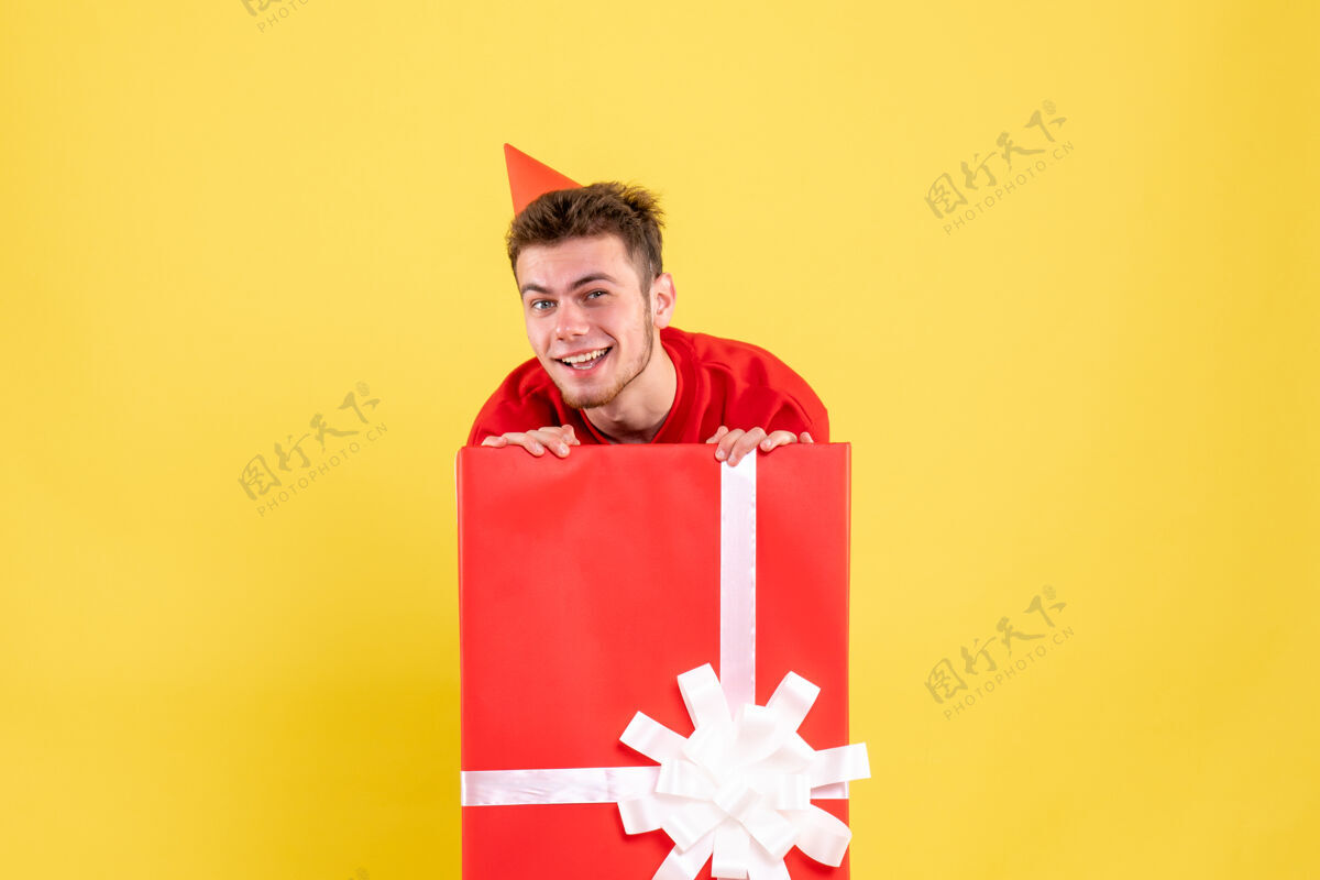 年轻男性正面图身着红衫的男青年在礼品盒内微笑着雪年年轻