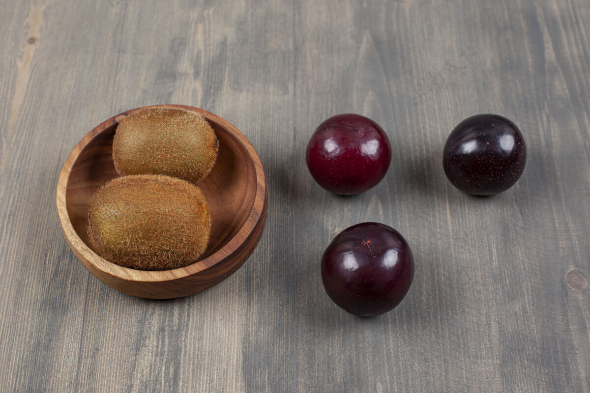 矿物质多汁的李子和奇异果放在木桌上高质量的照片素食者李子植物