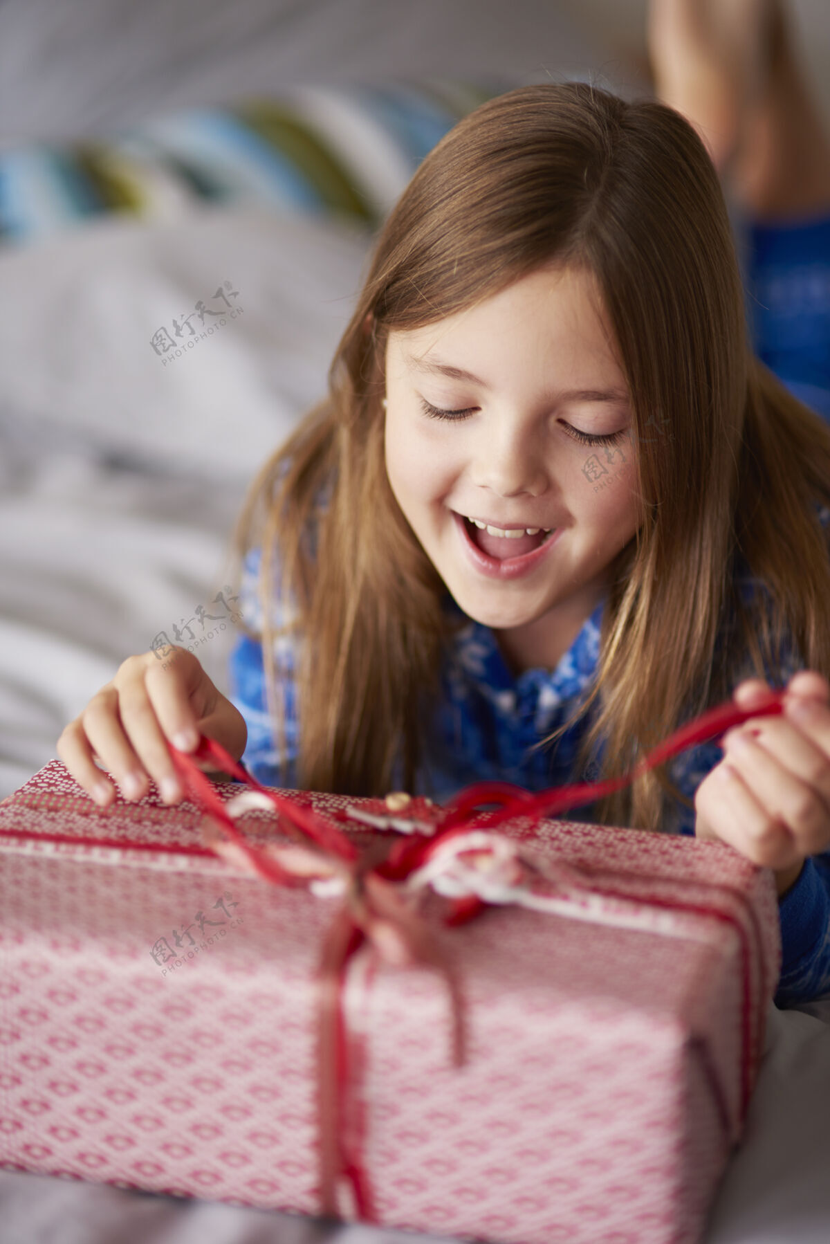 检查令人兴奋的女孩打开圣诞礼物家享受躺下