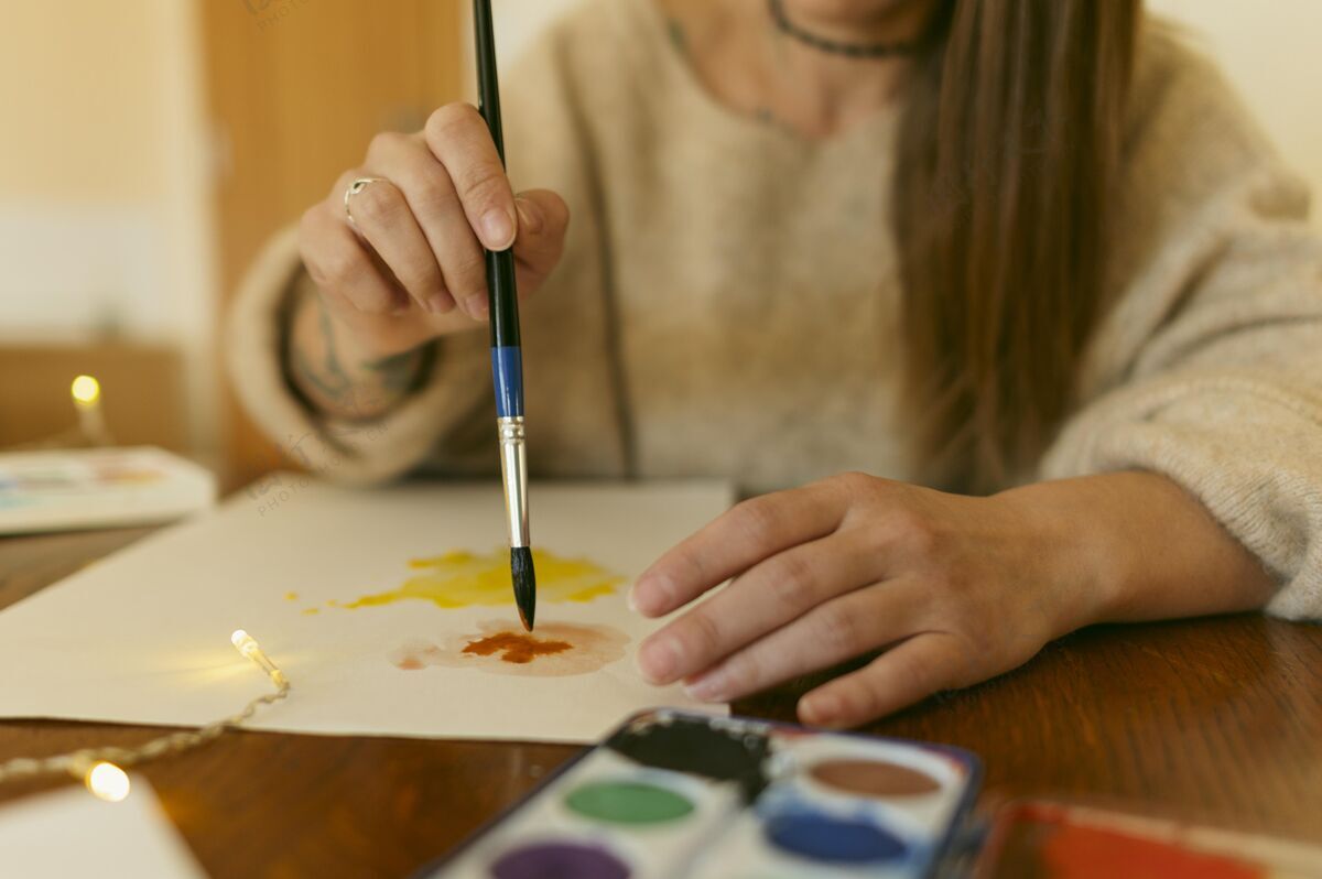爱好特写艺术家使用画笔在纸上家室内艺术