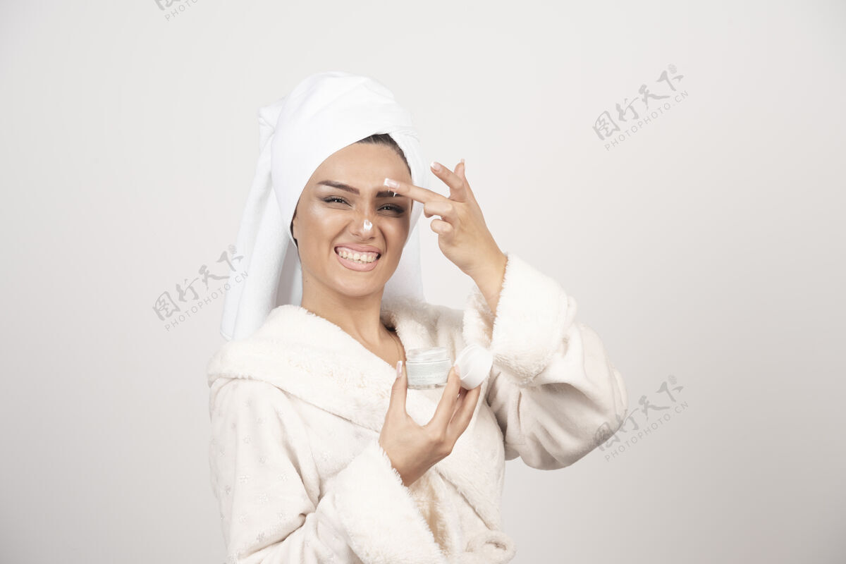 年轻穿着浴衣涂面霜的年轻女人毛巾女人人