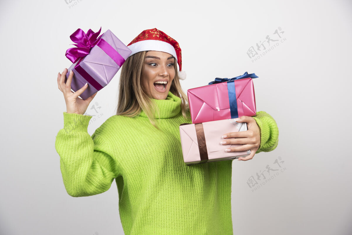 持有年轻微笑的女人手里拿着圣诞礼物美丽节日季节