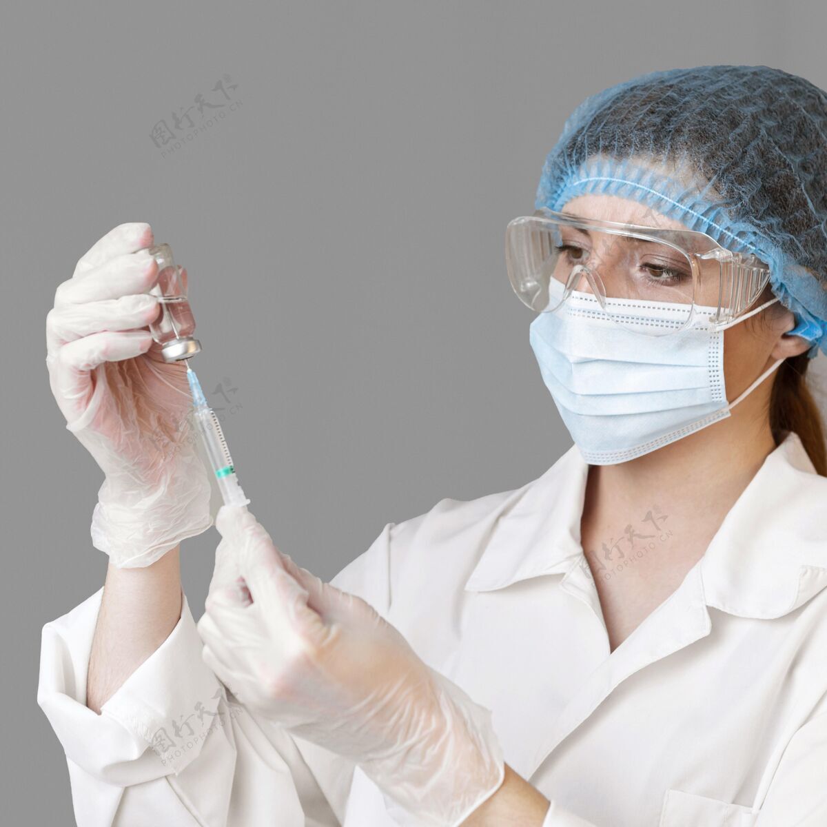 女人女科学家戴着安全眼镜和装有注射器的发网注射器女性科学家
