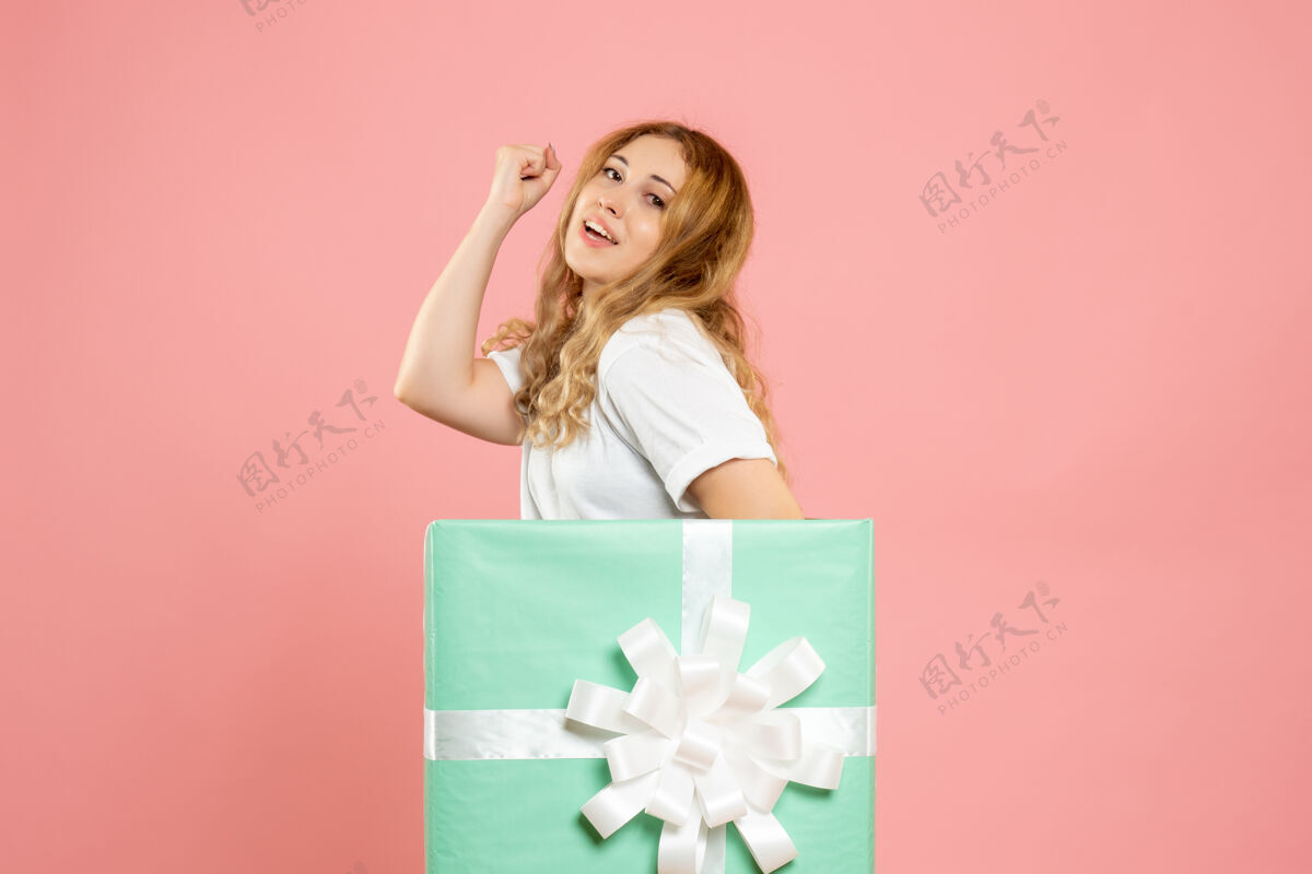 漂亮正面图：站在蓝色礼品盒内的年轻女性站着颜色粉色