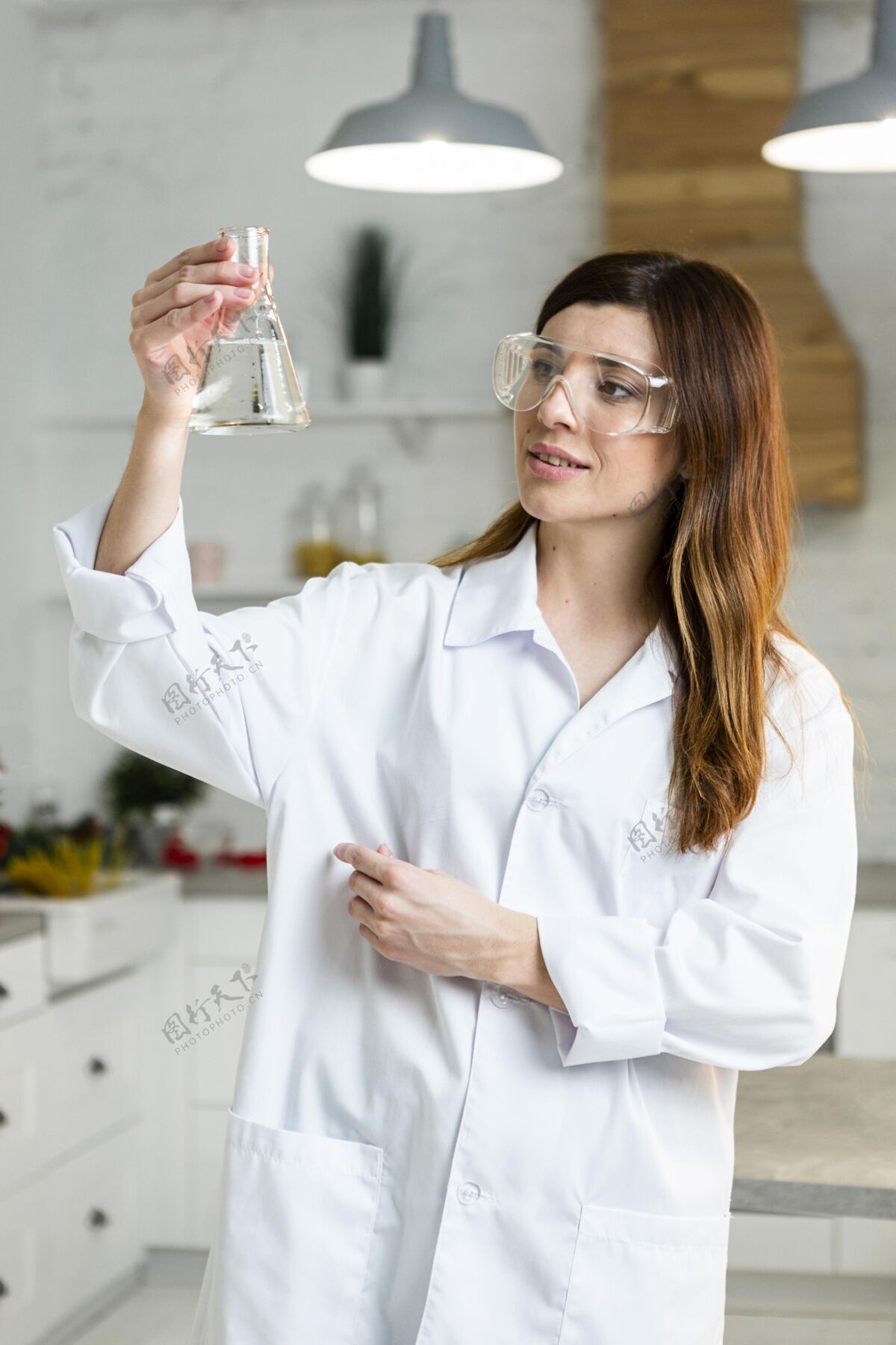 研究员女科学家戴着安全眼镜拿着试管在实验室里的正视图化学家研究安全眼镜