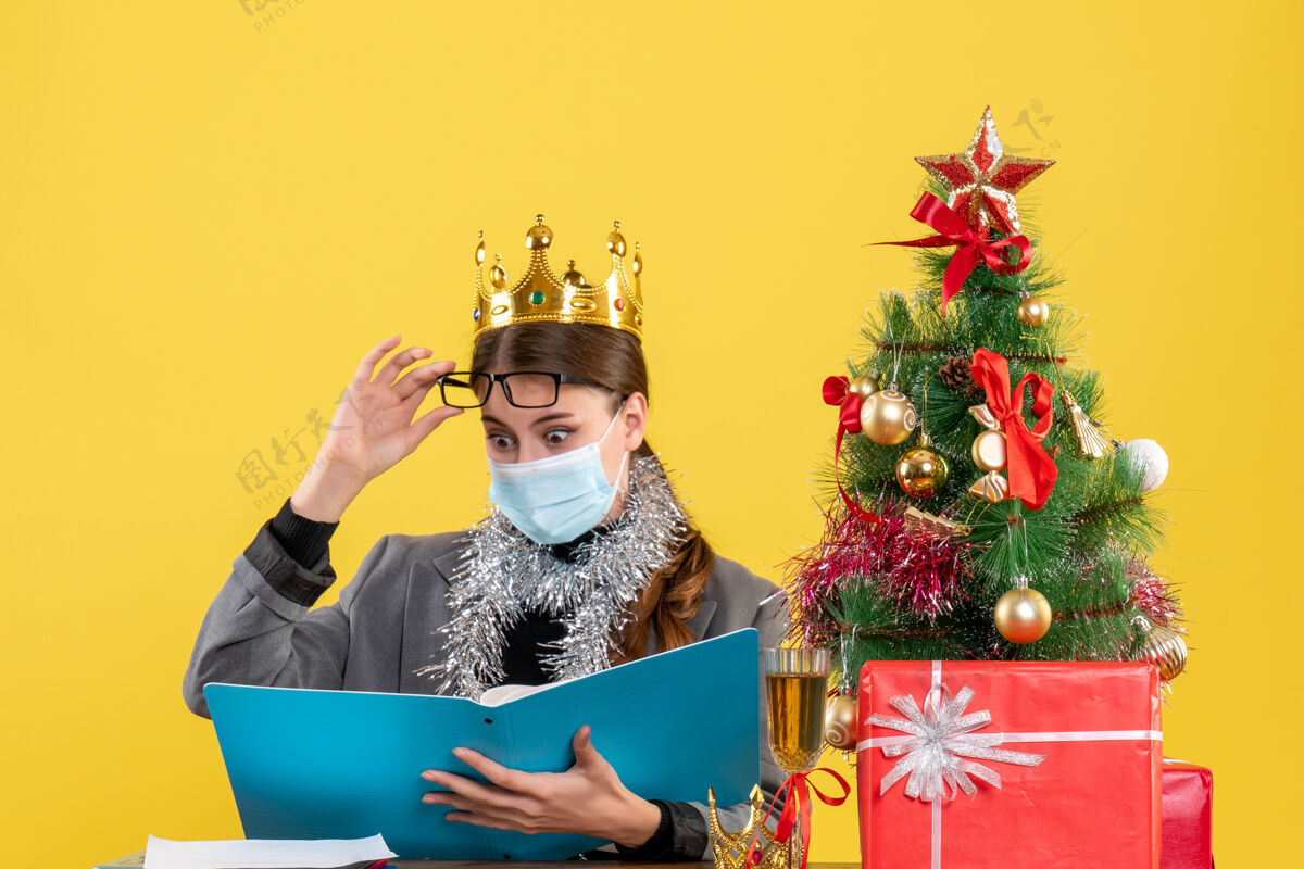皇冠正面图戴皇冠的年轻女孩摘下眼镜圣诞树和鸡尾酒礼物女孩年轻人树