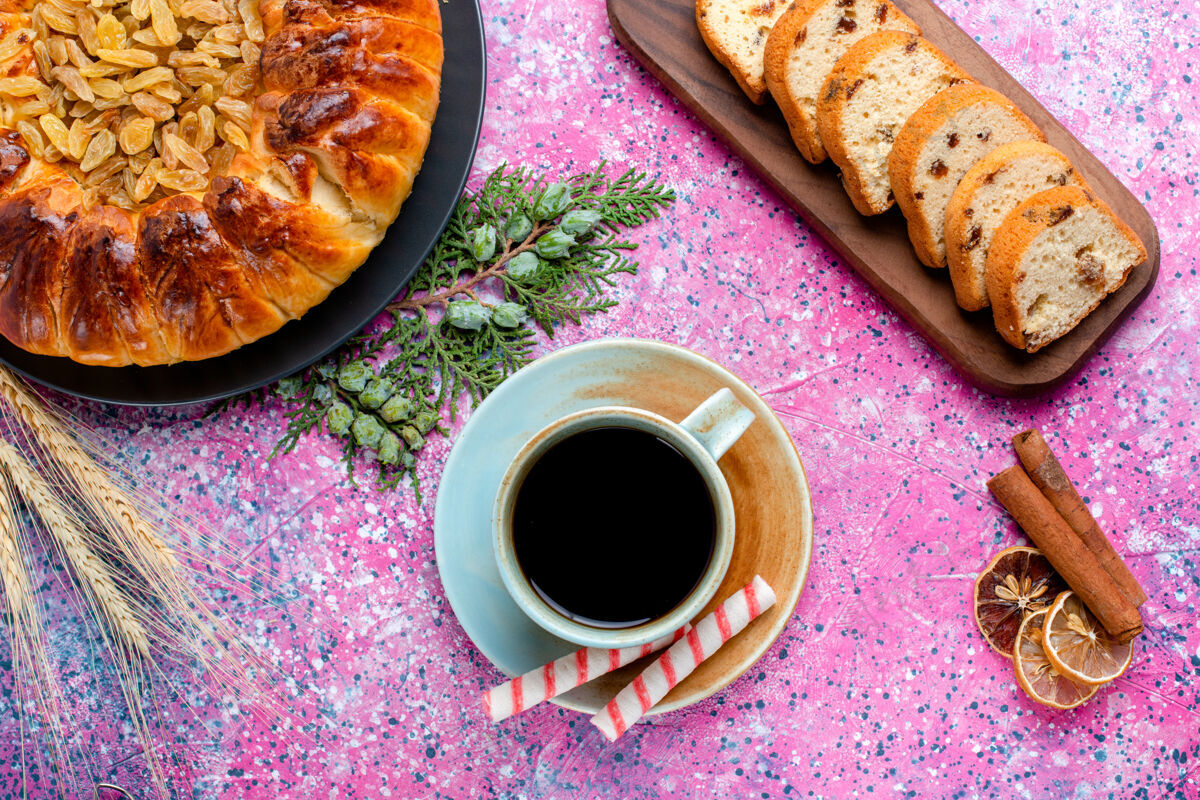 咖啡俯瞰美味的葡萄干蛋糕 咖啡杯放在浅粉色的表面上烤馅饼糖甜饼干饼干的颜色杯子饼干热的
