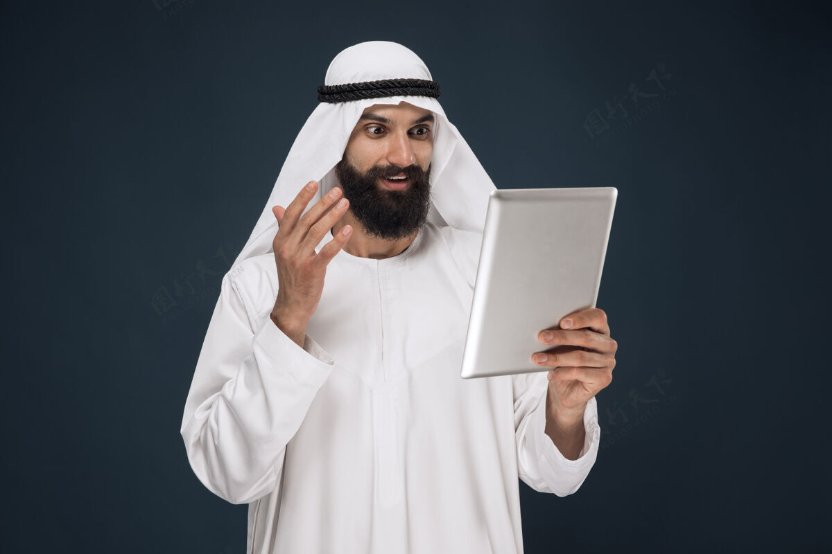 人物深蓝色工作室背景上的阿拉伯沙特商人肖像表情伊斯兰教