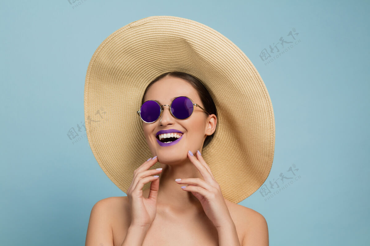 模特彩妆 帽子和太阳镜的美女肖像时尚的发型和发型夏天的颜色哈哈大笑女性看起来皮肤