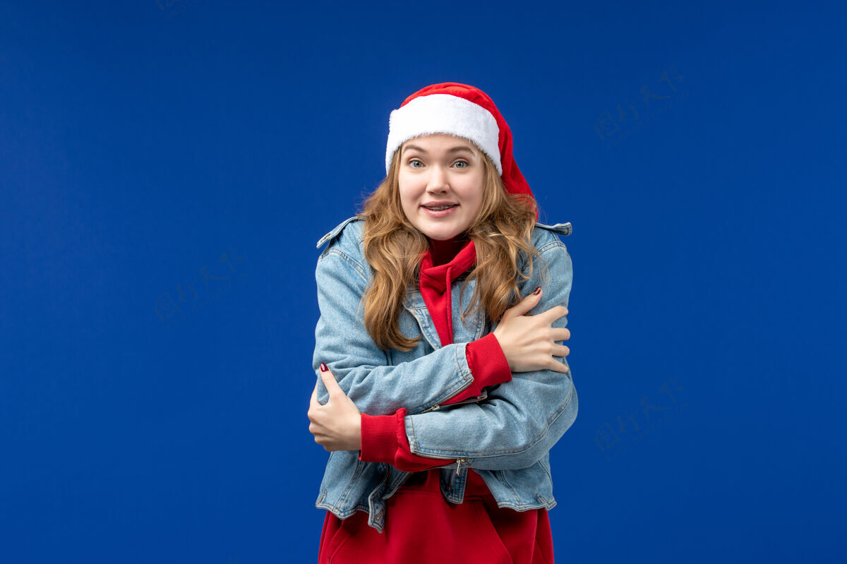 年轻蓝色书桌上冷得发抖的年轻女性情感圣诞假期休闲年轻女性人
