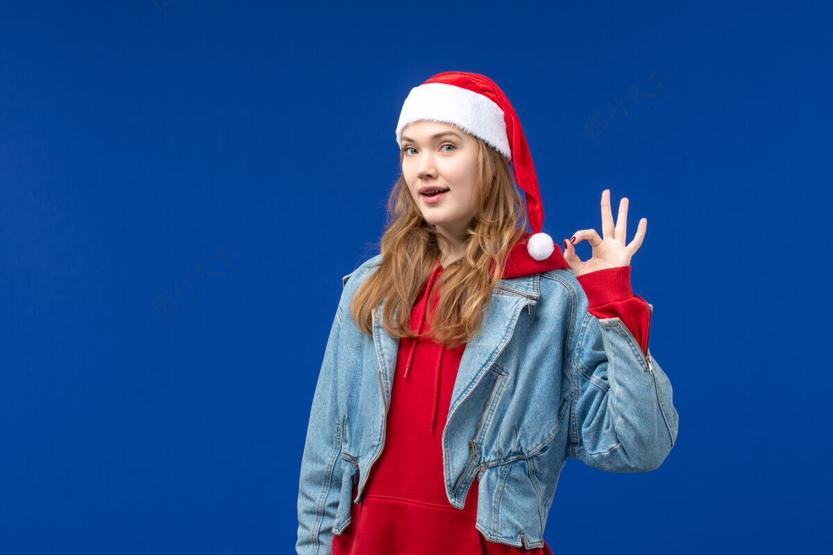 脸蓝色背景上 年轻女性喜气洋洋地表达着圣诞节的节日情感快乐人表情