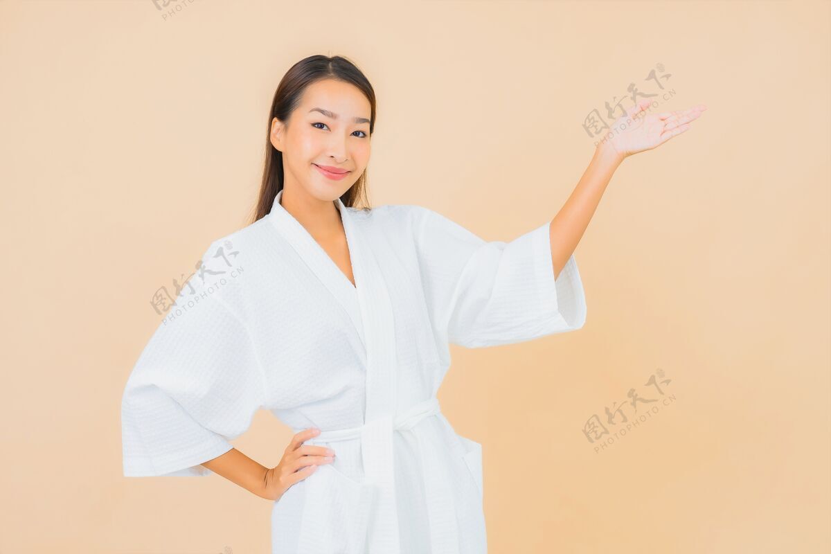 清洁肖像美丽的亚洲年轻女子穿着米色的微笑浴袍自然浴室女士
