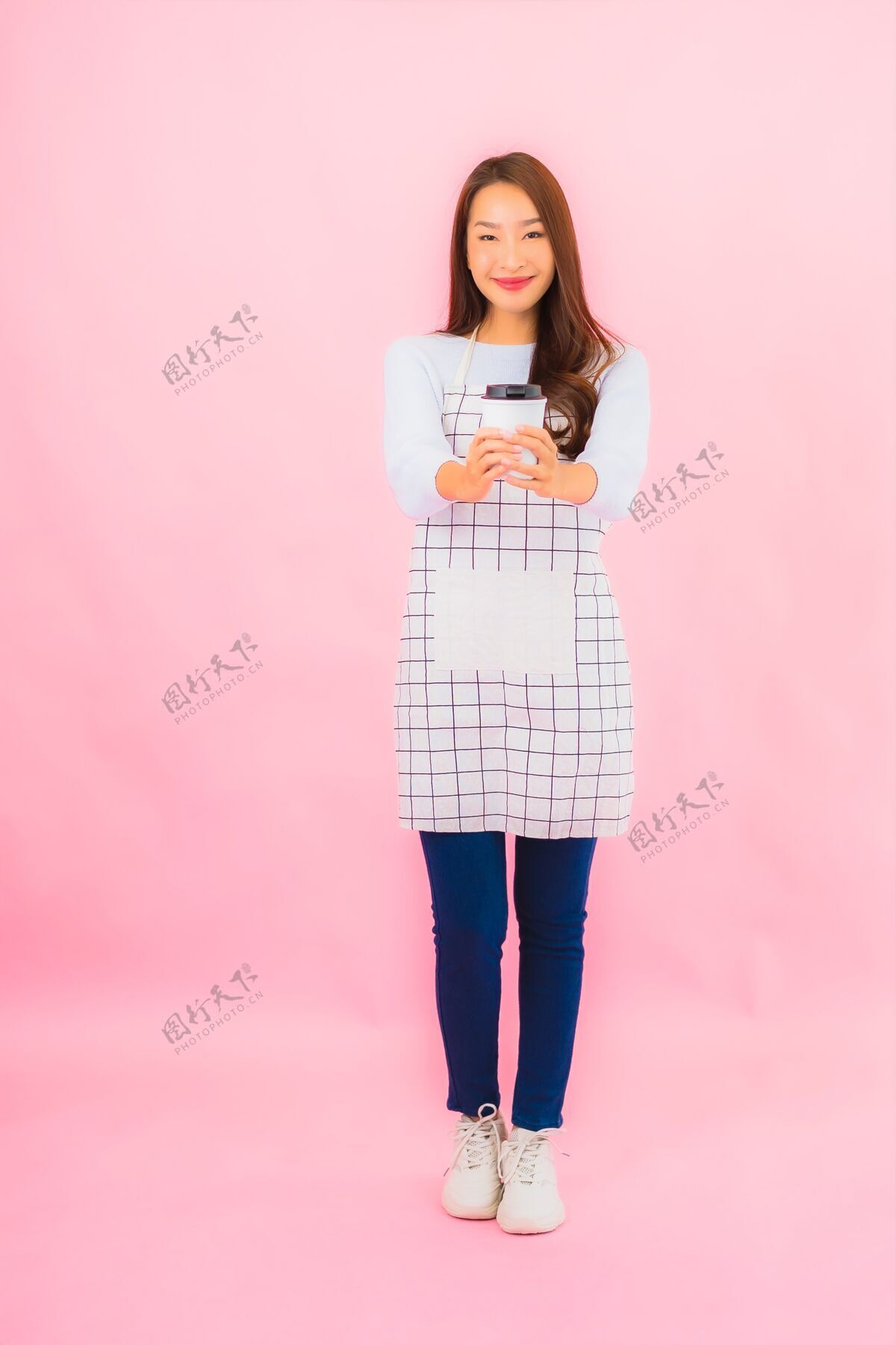 完美肖像美丽的亚洲年轻女子在厨房穿着围裙在粉红色的隔离墙上泰式肖像成人