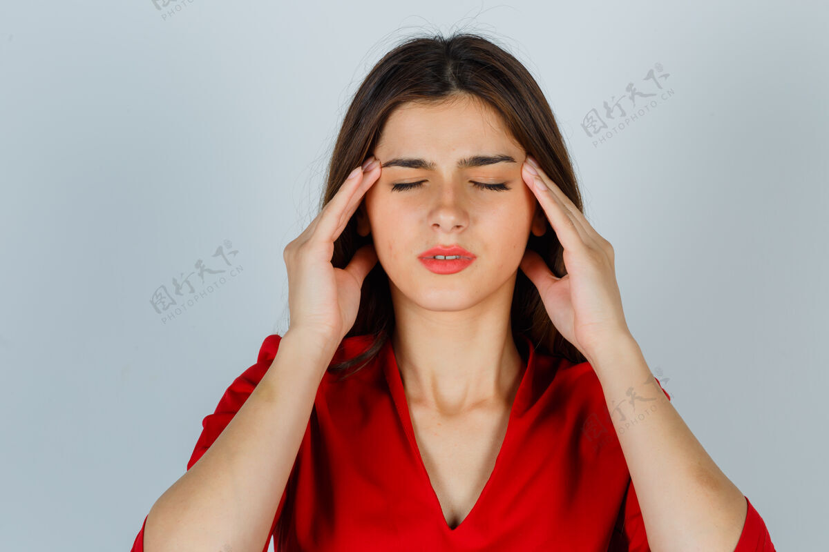 衬衫穿着红衬衫擦太阳穴的年轻女士 看上去很疲惫技术女商务偏头痛