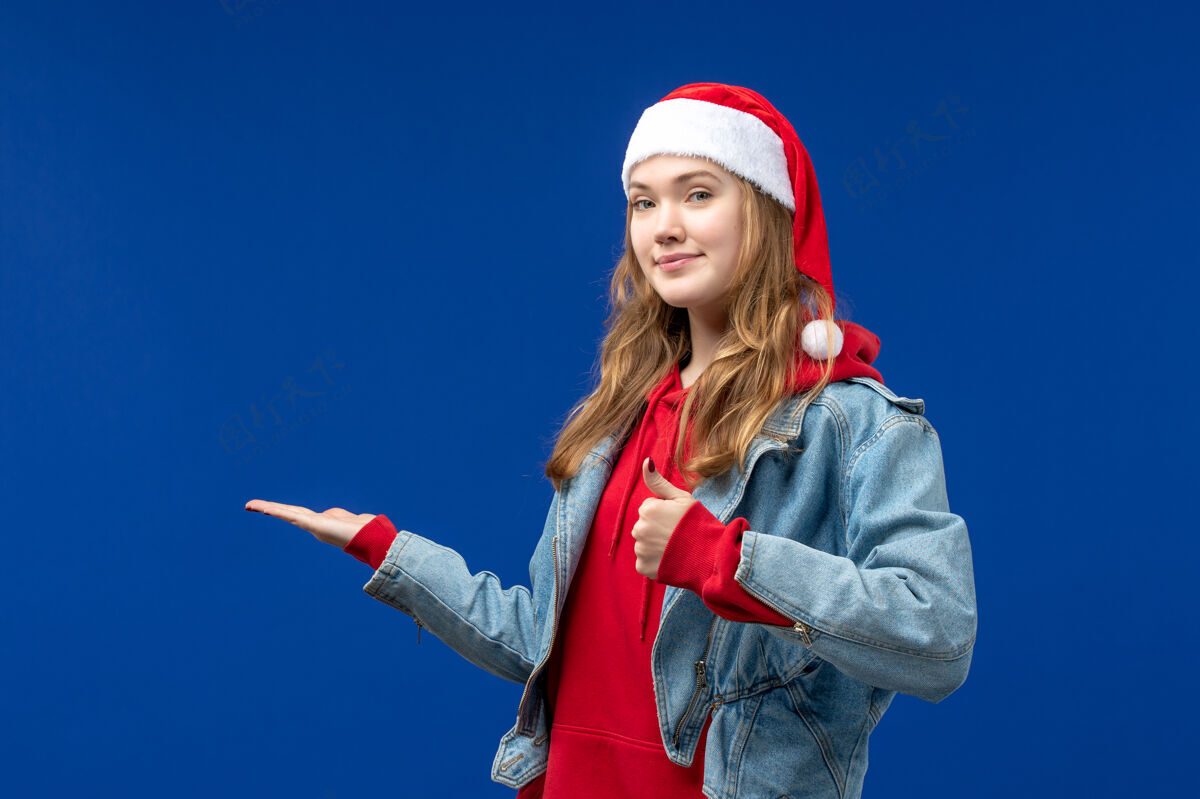 人正面图：年轻的女性在蓝色的桌子上微笑 圣诞节的情感色彩蓝色前面漂亮