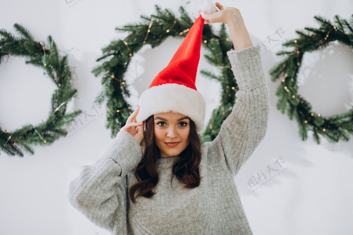 笑圣诞节戴圣诞帽的年轻女子积极圣诞老人礼物