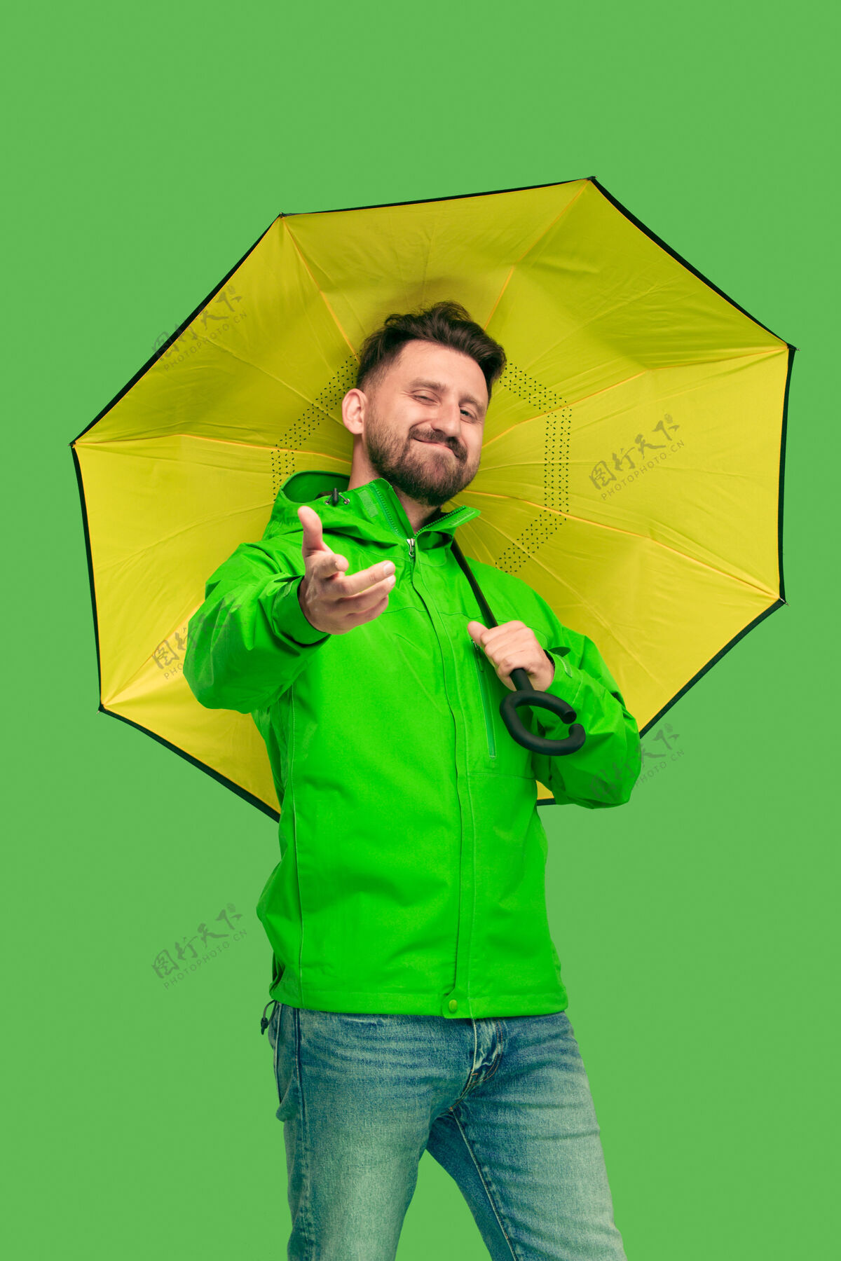 休闲帅气的胡须微笑的年轻人拿着雨伞看着镜头男人赢树