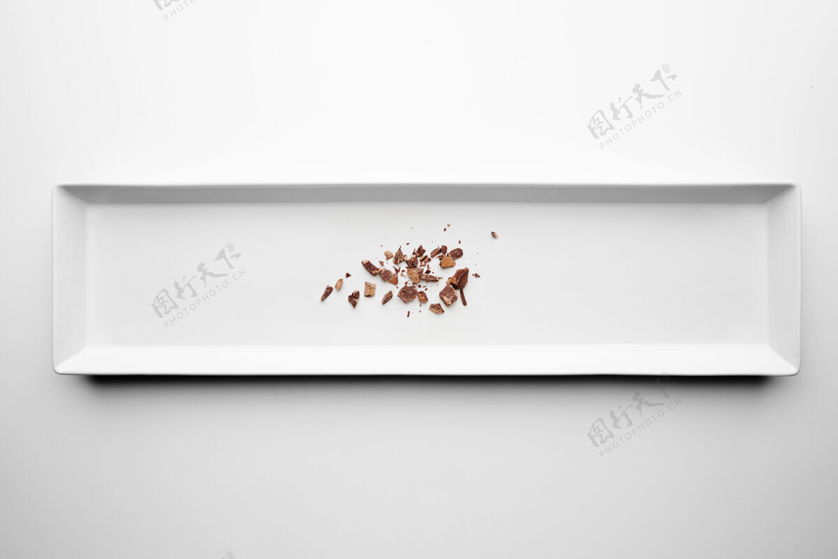 面包屑巧克力屑孤立在中心矩形陶瓷板白色桌子的背景甜点工作室拍摄抗氧化剂