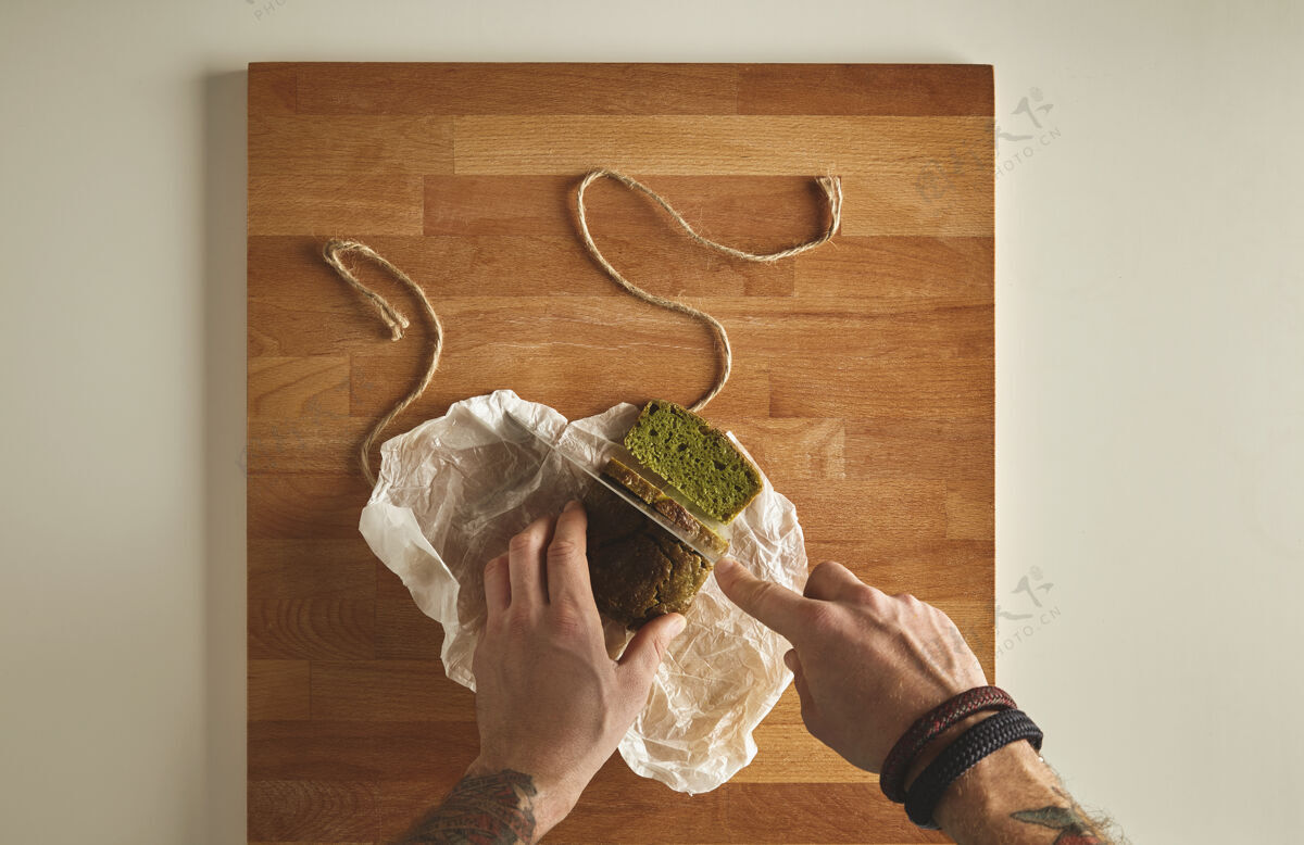 国家野蛮人纹身手切健康菠菜自制绿色乡村面包片上有复古刀木板白色桌面视图深度健康烹饪