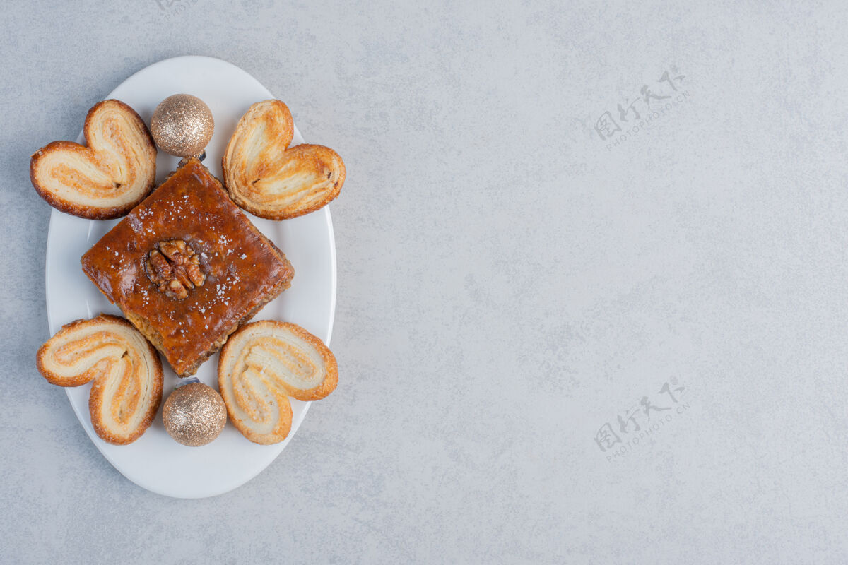 美味一个烤面包和片状饼干放在一个盘子上 大理石表面有一个装饰物糖果曲奇美食