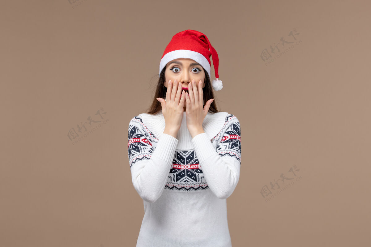 年份前视图年轻女子在棕色背景上惊讶的表情新年情绪圣诞节惊讶棕色新