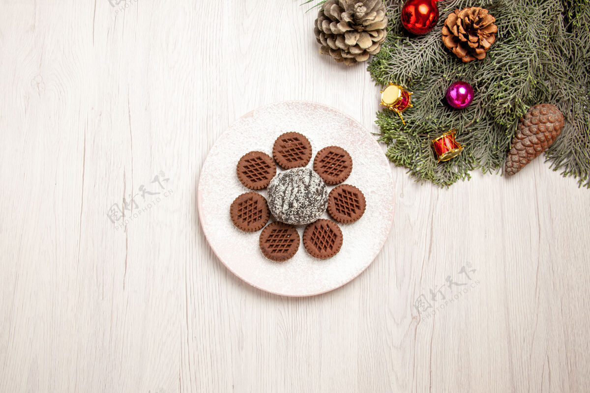 饼干俯瞰美味的巧克力饼干和小可可蛋糕上的白色碗珠宝可可