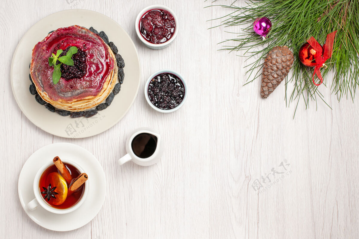 清淡俯瞰美味的果冻煎饼和葡萄干果冻和茶浅白色午餐早餐杯子