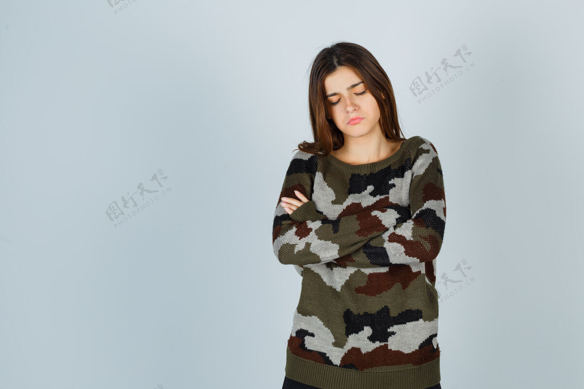 成人穿毛衣的年轻女士交叉双臂站着 看上去很悲伤女性交叉肖像